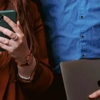 Kobieta z telefonem i mężczyzna z laptopem – praca nad kampaniami reklamowymi