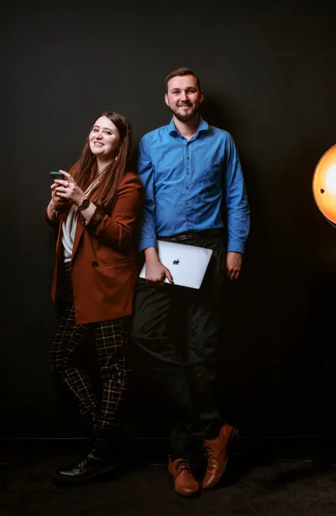 Zespół digital grow – kobieta z telefonem i mężczyzna z laptopem w studiu